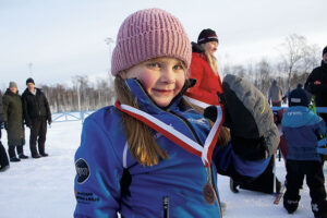 Freja Danielsson Åsander, 6 år tävlandes för Härnösands brukshundklubb, tar stolt emot sin medalj efter loppet.