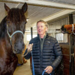 Ingvar Nyberg med två av sina hästar i stallet. Han tillhör eliten bland landets amatörkuskar och som pensionär har han gott om tid för sin älskade hobby travet.