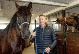 Ingvar Nyberg med två av sina hästar i stallet. Han tillhör eliten bland landets amatörkuskar och som pensionär har han gott om tid för sin älskade hobby travet.