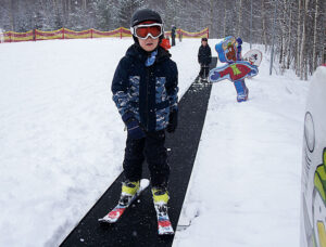 Alfons Sjögren, 6 år, på väg upp på rullbandet i barnbacken.