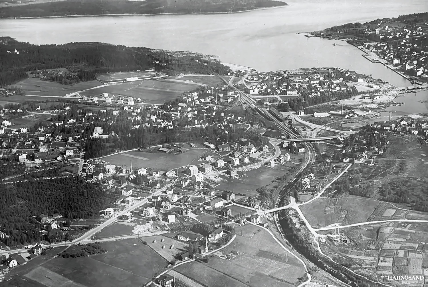 På Oscar Bladhs flygfoto från 1936 ser man hur järnvägen sveper i en s-formad kurva. Fastlandet var området som skulle bebyggas med små flerfamiljshus eller egnahem, en så kallad trädgårdsstad.