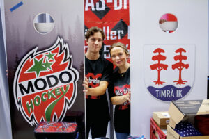 Hugo Björndahl och Molly Maberg visar upp cornholebrädor med Modo och Timråemblem som fanns att köpa i arenan.