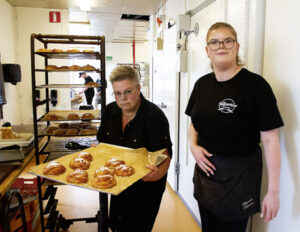 Moa Mellander t.h, får hjälp av Anki Lindberg att bära ut vaniljbullar till kunderna.